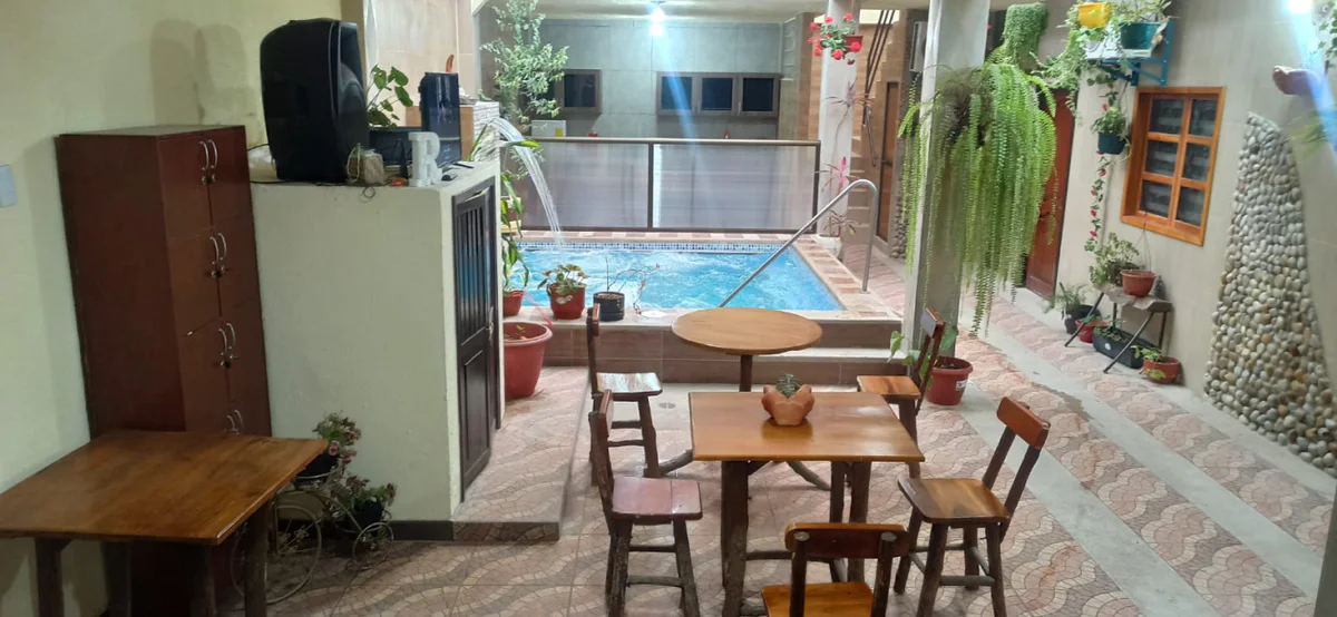 Wooden tables and plants beside SIRONA's indoor pool.